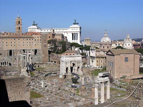 Altes Rom - Forum Romanum. Blick auf das Arco di Settimio Severo und die 3 Säulen des Tempio di Castore e Polluce. Im Hintergrund erhebt sich das Monumento a Vittorio Emannuelle auf der Piazza Venezia